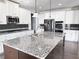 Modern kitchen with stainless steel appliances, white cabinets, large island, and dark backsplash at 3988 Two Bridge Drive, Buford, GA 30519