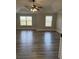 Sunlit primary bedroom with hardwood floors, neutral walls, tray ceiling, and large windows at 3988 Two Bridge Drive, Buford, GA 30519
