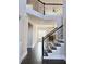 Staircase with dark wood handrail offering a view to living room with fireplace and coffered ceiling at 3988 Two Bridge Drive, Buford, GA 30519