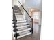 Elegant staircase with iron spindles and carpeted steps leading to the upper level at 3988 Two Bridge Drive, Buford, GA 30519
