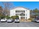 Exterior view of a light grey building, with a central staircase leading to the upper floors and parking in front at 1321 Keys Lake Ne Dr, Brookhaven, GA 30319