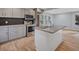 Open-concept kitchen with stainless steel appliances, gray cabinets, and a granite island at 2195 Burroughs Ave, Atlanta, GA 30315
