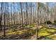 Sloped backyard with stone patio surrounded by mature trees at 285 Blackstock Rd, Villa Rica, GA 30180