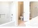 Bathroom featuring a white tub-shower combo and a toilet next to an open white door at 285 Blackstock Rd, Villa Rica, GA 30180