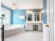 Stylish bathroom featuring a soaking tub, decorative window, and a spacious vanity at 285 Blackstock Rd, Villa Rica, GA 30180