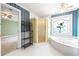 Bright bathroom boasting a luxurious tub, separate shower, and views to a bedroom at 285 Blackstock Rd, Villa Rica, GA 30180