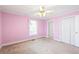 Cozy bedroom with pink walls, natural light, and a double door closet offering ample storage at 285 Blackstock Rd, Villa Rica, GA 30180