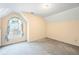 A brightly lit bedroom with tan walls and a large window covered by a floral curtain at 285 Blackstock Rd, Villa Rica, GA 30180