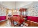 Traditional dining room featuring hardwood floors, floral wallpaper, and a cherry wood table and china cabinet at 285 Blackstock Rd, Villa Rica, GA 30180