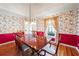 Elegant dining room with hardwood floors, floral wallpaper, a large table, and natural light from the window at 285 Blackstock Rd, Villa Rica, GA 30180