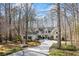 Charming exterior view of home with beautiful landscaping, long drive, and wooded surroundings at 285 Blackstock Rd, Villa Rica, GA 30180