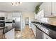 Bright kitchen with stainless steel appliances, white cabinets, and black countertops and backsplash at 285 Blackstock Rd, Villa Rica, GA 30180