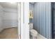 Walk-in closet with shelving leading to a toilet and patterned wallpaper at 285 Blackstock Rd, Villa Rica, GA 30180