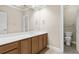 Well-lit bathroom with a large mirror, white countertop, and wooden cabinets, complemented by neutral walls at 160 Antler Trl, Alpharetta, GA 30005