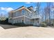 Impressive home featuring a multi-level deck, set against a backdrop of lush greenery and a clear sky at 160 Antler Trl, Alpharetta, GA 30005