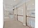 Upstairs hallway with hardwood railing, arched entryways and trim details, and windows overlooking the backyard at 160 Antler Trl, Alpharetta, GA 30005
