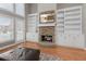 Bright living room featuring a stone fireplace, built-in bookshelves, and access to outdoor space at 160 Antler Trl, Alpharetta, GA 30005