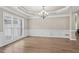 Living room featuring hardwood floors, a coffered ceiling, wainscoting and three windows at 160 Antler Trl, Alpharetta, GA 30005