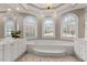 Luxurious main bathroom features a soaking tub, double vanities, and arched windows at 160 Antler Trl, Alpharetta, GA 30005