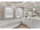 Elegant main bathroom with a large soaking tub, arched windows, and a vanity area at 160 Antler Trl, Alpharetta, GA 30005