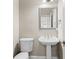 Classic powder room with pedestal sink, decorative mirror, and neutral color palette at 160 Antler Trl, Alpharetta, GA 30005
