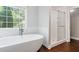 Bathroom showcasing a modern freestanding tub, a glass-enclosed shower, and wood-look flooring at 274 Westchester Club Dr, Hiram, GA 30141