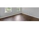 An interior view of a simple bedroom showcasing hardwood floors and natural light from two windows at 274 Westchester Club Dr, Hiram, GA 30141