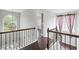 Upstairs hallway with hardwood floors, staircase railing, and natural light coming from windows at 274 Westchester Club Dr, Hiram, GA 30141