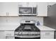 Modern kitchen with stainless steel gas range, microwave, and white tile backsplash at 274 Westchester Club Dr, Hiram, GA 30141