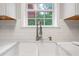 Close-up of a modern kitchen sink with a white farmhouse basin and stainless steel faucet at 274 Westchester Club Dr, Hiram, GA 30141