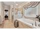 Bathroom featuring a luxurious soaking tub, tiled shower, and decorative window treatment at 244 Lotus Cir, Mcdonough, GA 30252
