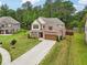 Aerial view of a two-story home with brick and siding, landscaped yard, and long driveway at 244 Lotus Cir, Mcdonough, GA 30252