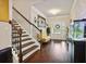 Warm foyer with hardwood floors, staircase, decorative wall art, and view to the front door at 244 Lotus Cir, Mcdonough, GA 30252