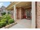 Inviting front porch with brick columns, manicured shrubs, and a decorative wreath on the door at 244 Lotus Cir, Mcdonough, GA 30252