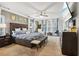 Main bedroom with large windows, ceiling fan, mounted tv, and upholstered headboard at 244 Lotus Cir, Mcdonough, GA 30252