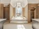 Elegant bathroom featuring a soaking tub beneath a window and arched ceiling at 607 Delphinium Nw Blvd, Acworth, GA 30102