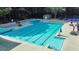 A large swimming pool with lounge chairs and umbrellas surrounded by concrete at 607 Delphinium Nw Blvd, Acworth, GA 30102