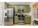 Bright kitchen featuring stainless steel appliances and charming green cabinetry at 28 Butler Park Ct, Dallas, GA 30157