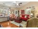 Cozy living room with a plush red sofa, hardwood floors, and natural light from large windows at 28 Butler Park Ct, Dallas, GA 30157