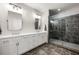 Bathroom with double vanity, white cabinets, and a modern glass-enclosed shower with dark tile at 714 Opera Ln, Alpharetta, GA 30009