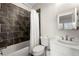 Bathroom with a shower/tub combo, marbled tile and a vanity with dark fixtures and lighting at 714 Opera Ln, Alpharetta, GA 30009