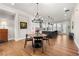 Dining area with a round table, modern chandelier, and adjacent kitchen island and bar seating at 714 Opera Ln, Alpharetta, GA 30009