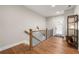 Second floor hallway with wood floors, staircase, modern lighting, and decorative shelves at 714 Opera Ln, Alpharetta, GA 30009