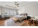 Bright main bedroom with hardwood floors, large windows, ceiling fan, and comfortable seating area at 714 Opera Ln, Alpharetta, GA 30009