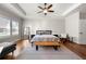 Spacious main bedroom featuring a tray ceiling, ceiling fan, and large windows with wood floors at 714 Opera Ln, Alpharetta, GA 30009
