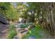 Landscaped backyard with stone steps leading to a patio and inviting seating area at 1111 Seaboard Nw Ave, Atlanta, GA 30318