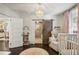 Bedroom with hardwood floors, crib, bookshelf, and sliding barn door to bathroom at 1111 Seaboard Nw Ave, Atlanta, GA 30318