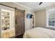 Bedroom with sliding barn door to ensuite bathroom and natural light from window at 1111 Seaboard Nw Ave, Atlanta, GA 30318