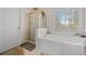 Bright bathroom featuring a soaking tub, glass enclosed shower and a view out the window at 231 Beechwood Ln, Stone Mountain, GA 30087