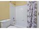 Bathroom featuring shower-tub combo, a standard toilet, and a dark floral-patterned curtain at 231 Beechwood Ln, Stone Mountain, GA 30087